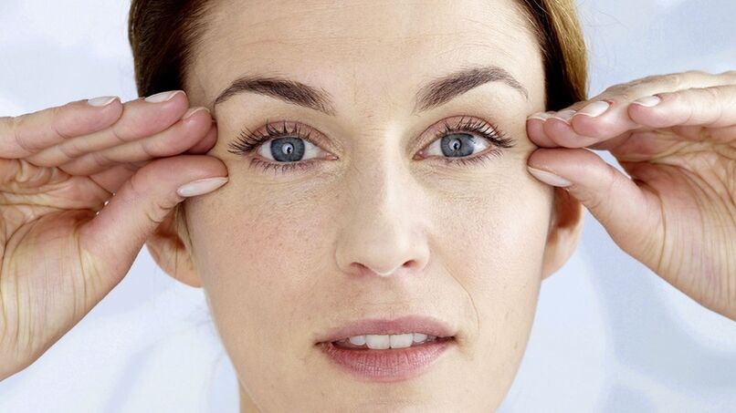 A woman holds her hands close to her eyes